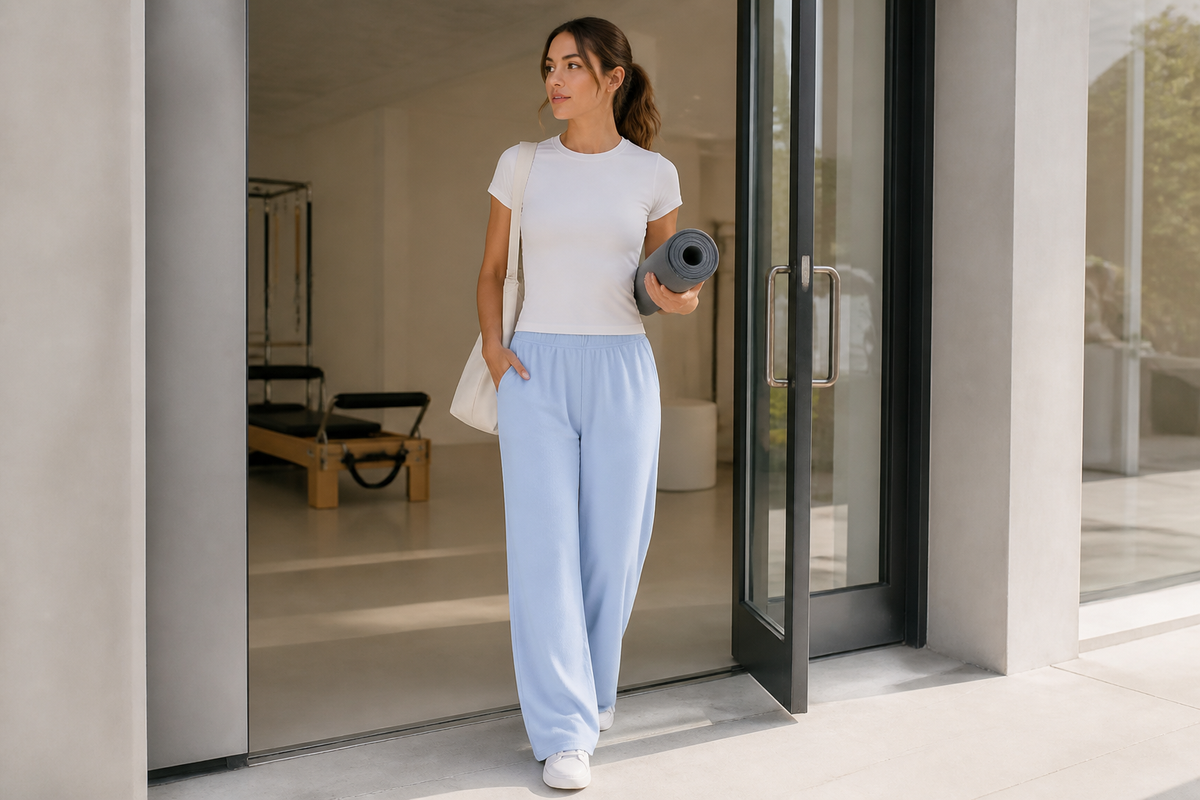 Adult woman leaving a Pilates studio in blue waffle-knit straight-leg sweatpants